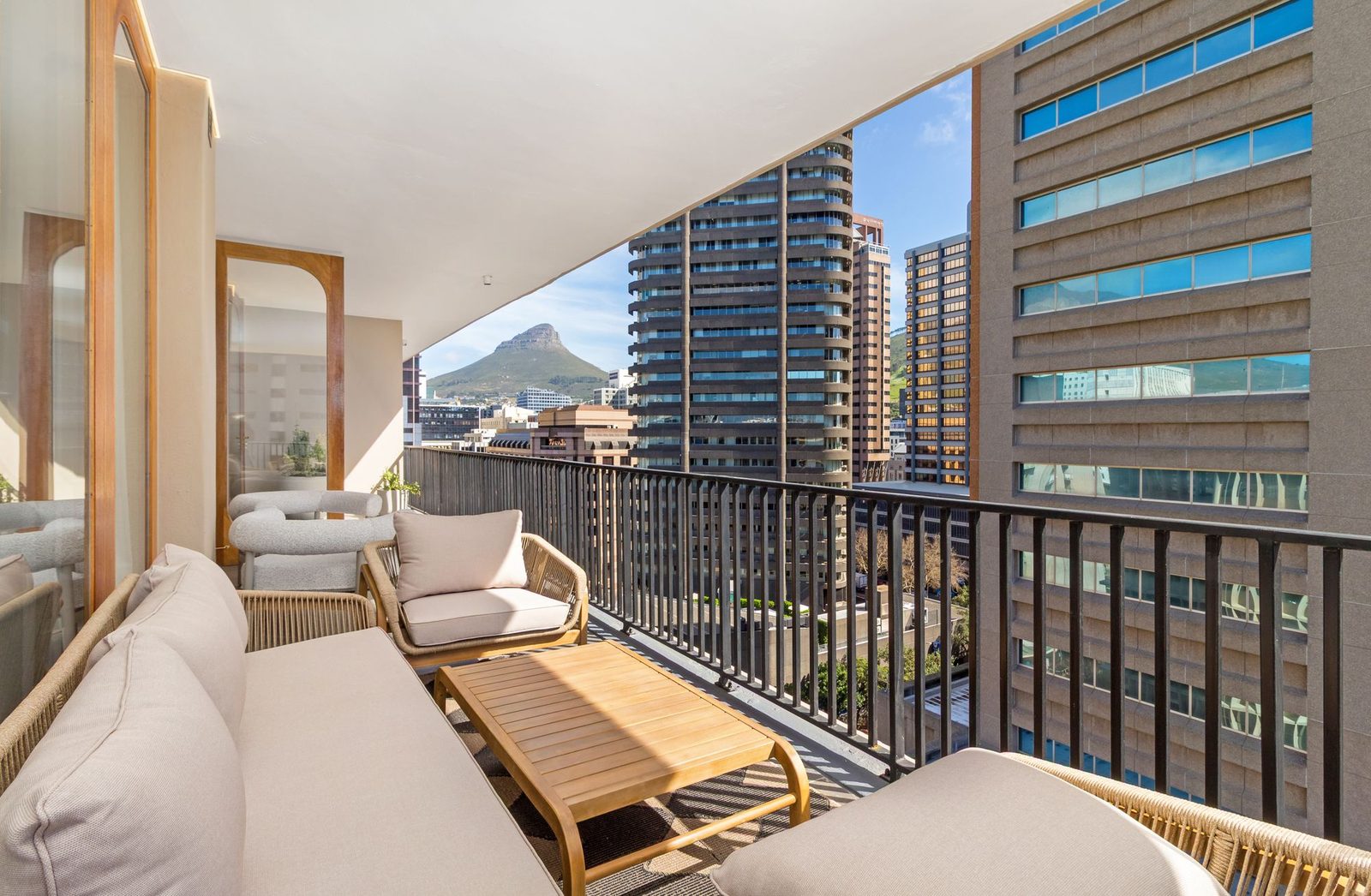 Balcony with rope lounge chairs and a view of Lion's Head between city towers