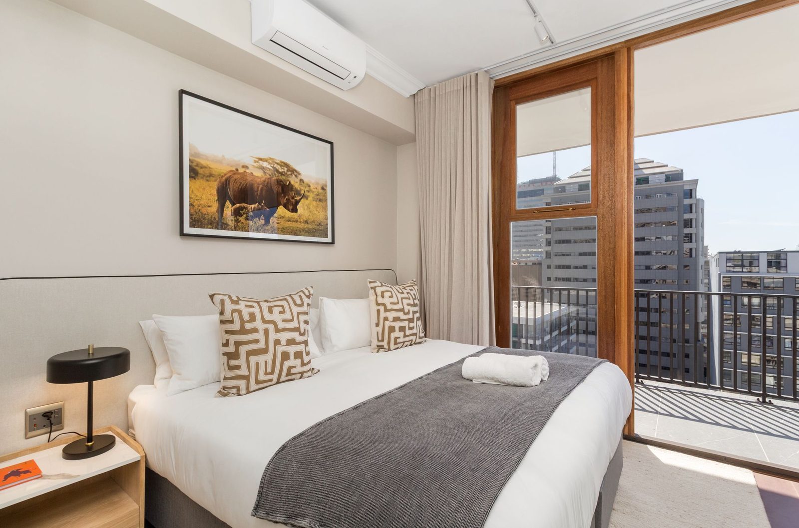 Bedroom with a wildlife print, patterned cushions and a balcony door