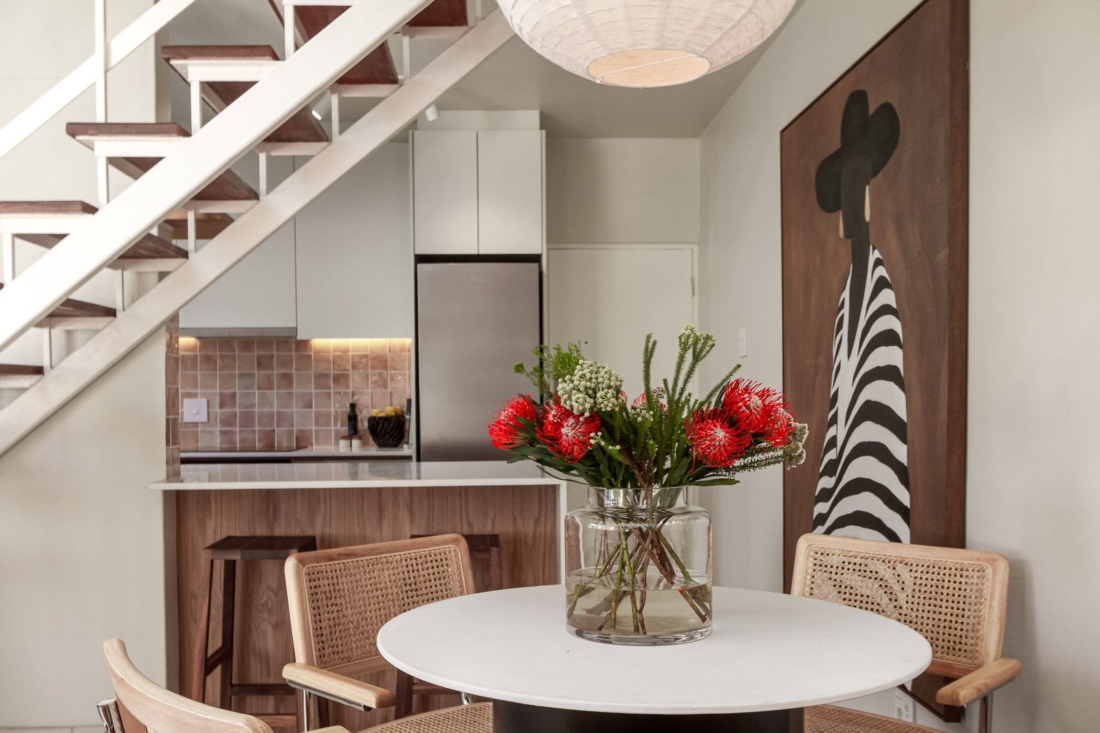 Platteklip: dining table with proteas beneath an open timber staircase