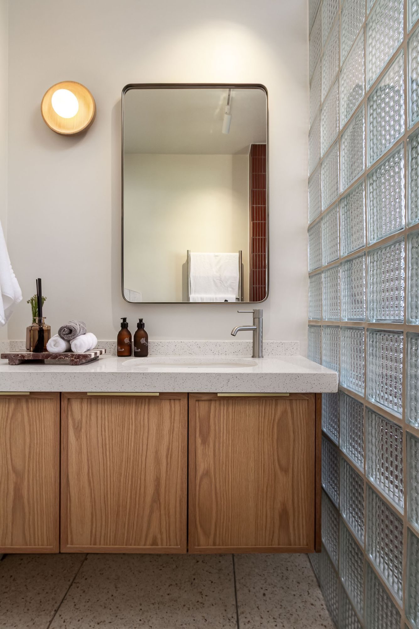 Platteklip: bathroom with an oak vanity, terrazzo top and a glass block wall