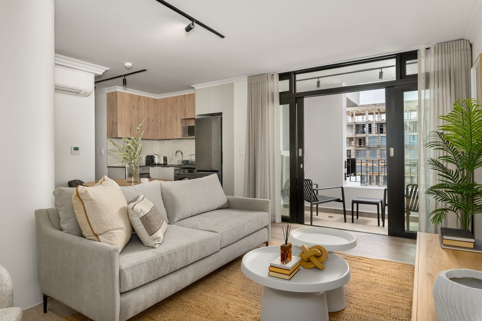The York, Cape Town: living room with a grey sofa opening onto a balcony
